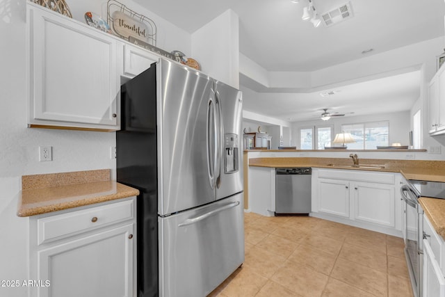 kitchen featuring white cabinetry, appliances with stainless steel finishes, sink, and light tile patterned floors