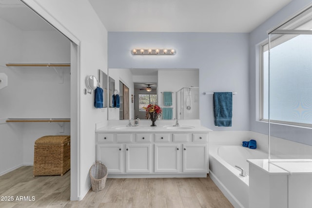 bathroom with hardwood / wood-style flooring, ceiling fan, vanity, and independent shower and bath