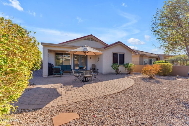 back of property featuring a patio area and outdoor lounge area