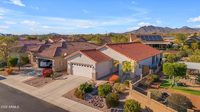 mediterranean / spanish house with a garage, a mountain view, and solar panels