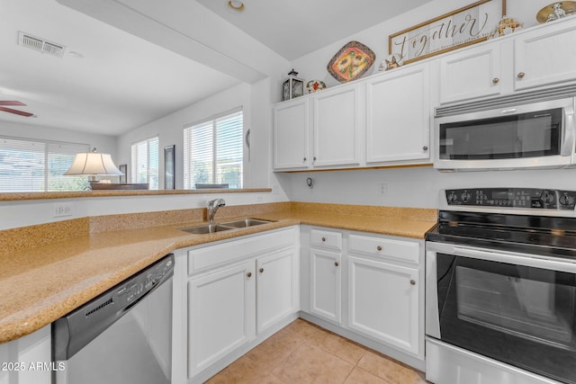 kitchen featuring stainless steel appliances, white cabinetry, and sink