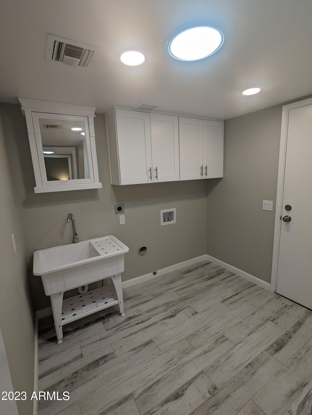 laundry area with cabinets, washer hookup, light hardwood / wood-style floors, and hookup for an electric dryer