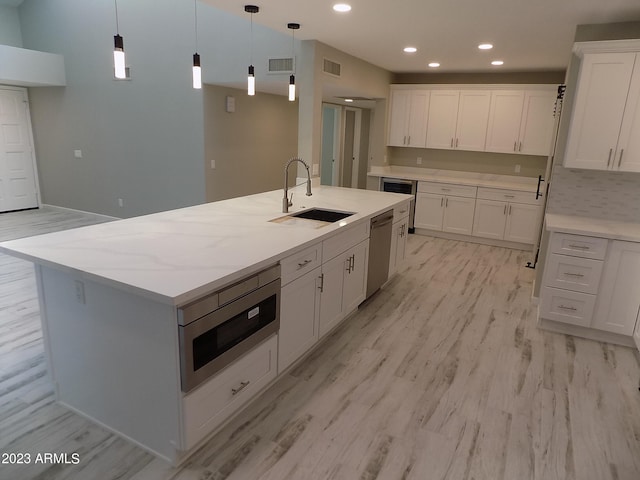 kitchen featuring light hardwood / wood-style floors, a kitchen island with sink, and sink