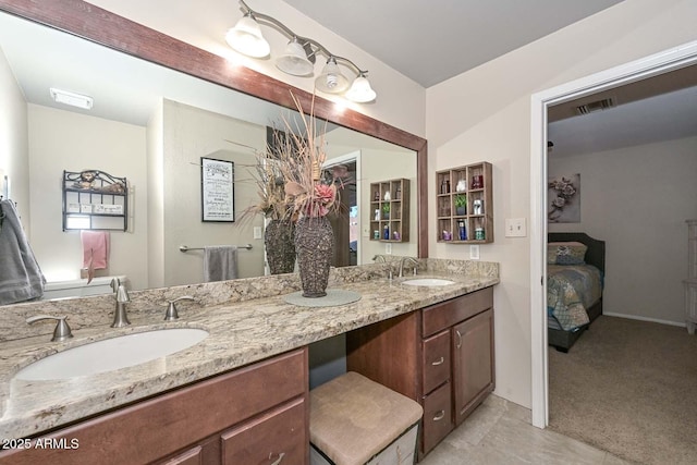 ensuite bathroom featuring ensuite bath, double vanity, visible vents, and a sink