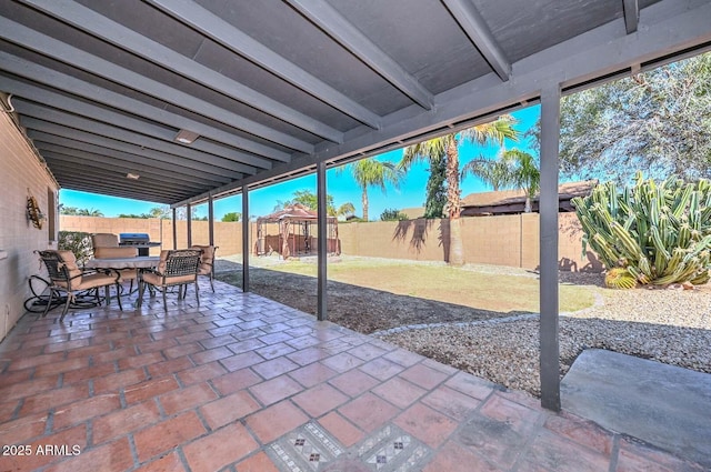 view of patio featuring outdoor dining area, a fenced backyard, and grilling area