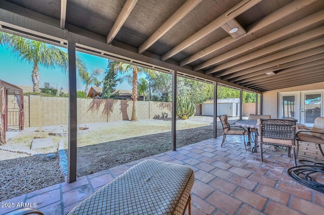 view of patio / terrace with a storage unit, an outbuilding, and a fenced backyard