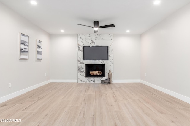 unfurnished living room with light hardwood / wood-style flooring, a fireplace, and ceiling fan