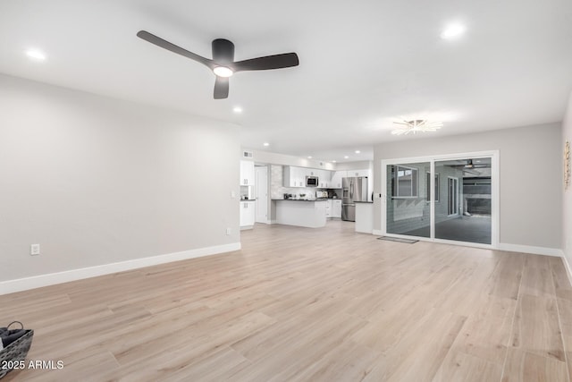 unfurnished living room featuring ceiling fan and light hardwood / wood-style floors