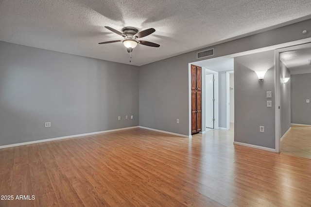 spare room with visible vents, baseboards, light wood-style flooring, and a ceiling fan