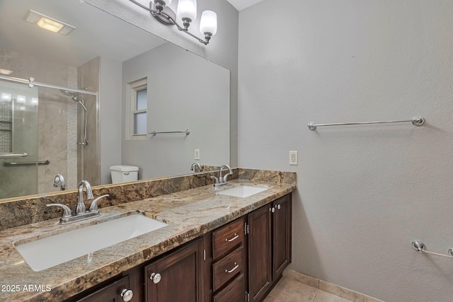 full bathroom featuring a sink, toilet, a stall shower, and double vanity