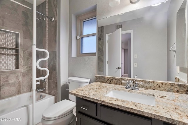 full bathroom with visible vents, toilet, bathtub / shower combination, vanity, and a textured wall