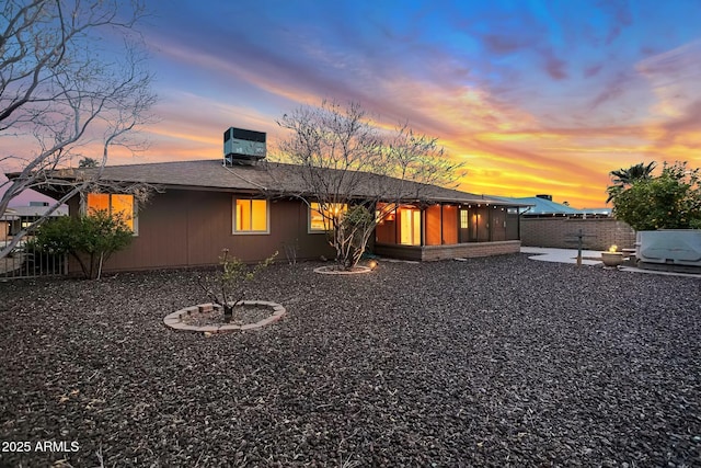 rear view of property featuring central air condition unit, a patio area, roof with shingles, and fence