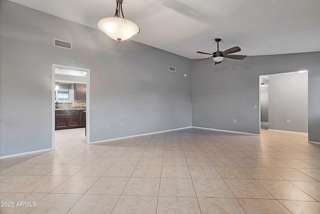 empty room with light tile patterned floors, visible vents, baseboards, and a ceiling fan