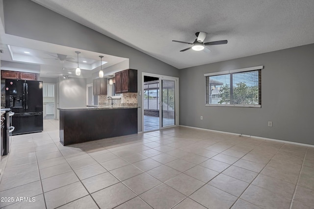 kitchen featuring a ceiling fan, black fridge with ice dispenser, open floor plan, a peninsula, and light tile patterned flooring