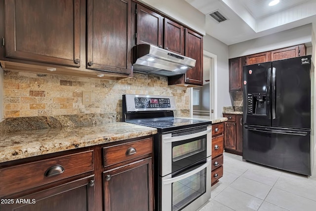 kitchen with visible vents, range with two ovens, light tile patterned flooring, black fridge with ice dispenser, and under cabinet range hood