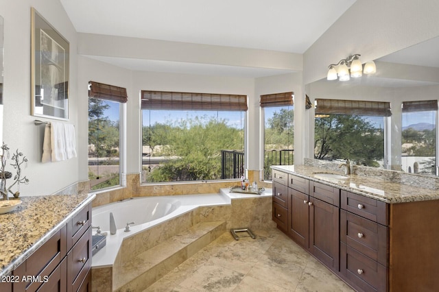 bathroom featuring vanity and tiled bath