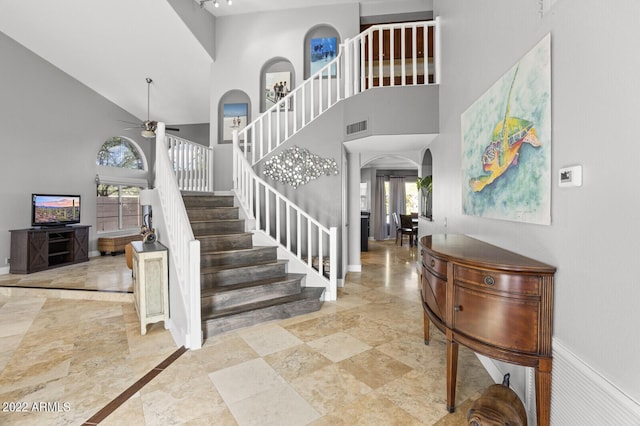 foyer featuring a towering ceiling and ceiling fan