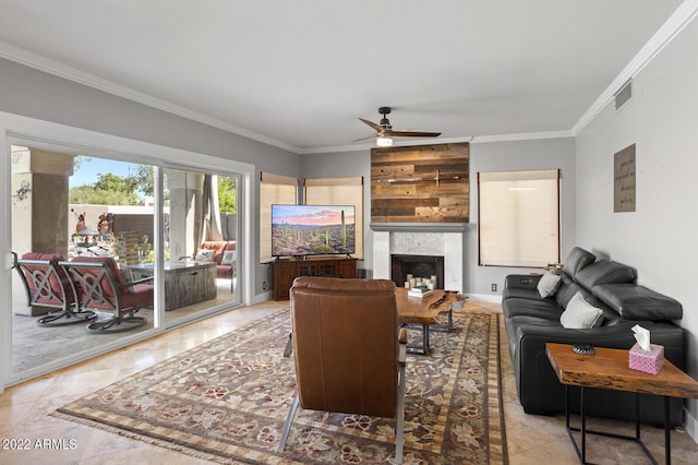 living room featuring crown molding, ceiling fan, and a fireplace