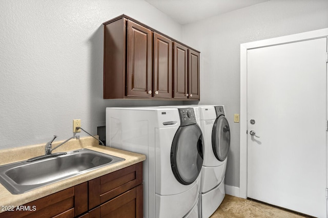 clothes washing area featuring cabinets, independent washer and dryer, and sink