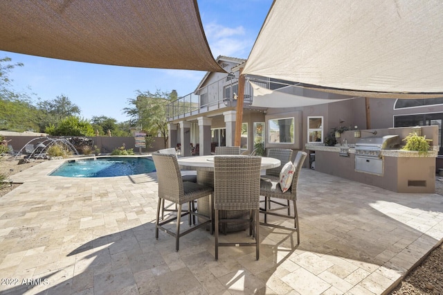 view of patio with pool water feature, exterior kitchen, area for grilling, a balcony, and a fenced in pool