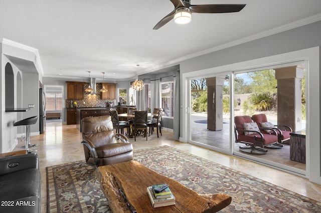 living room featuring crown molding, ceiling fan with notable chandelier, and light tile patterned flooring