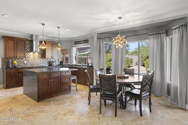 kitchen with tasteful backsplash, a kitchen island, pendant lighting, and wall chimney exhaust hood