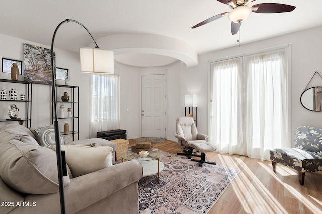 living area with a ceiling fan and wood finished floors