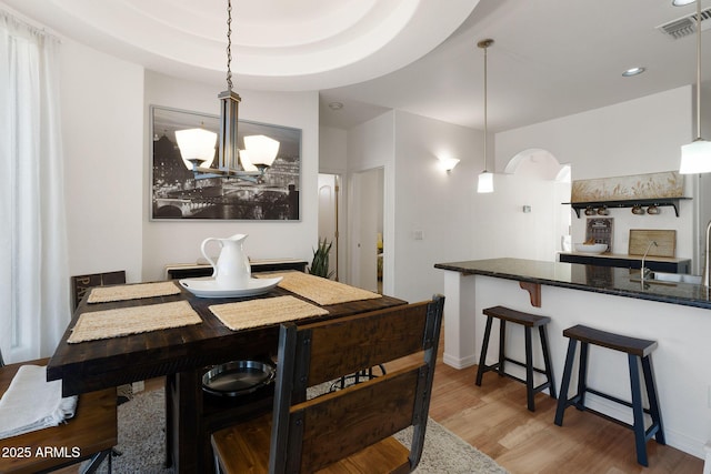 dining room with a chandelier, recessed lighting, wood finished floors, visible vents, and baseboards