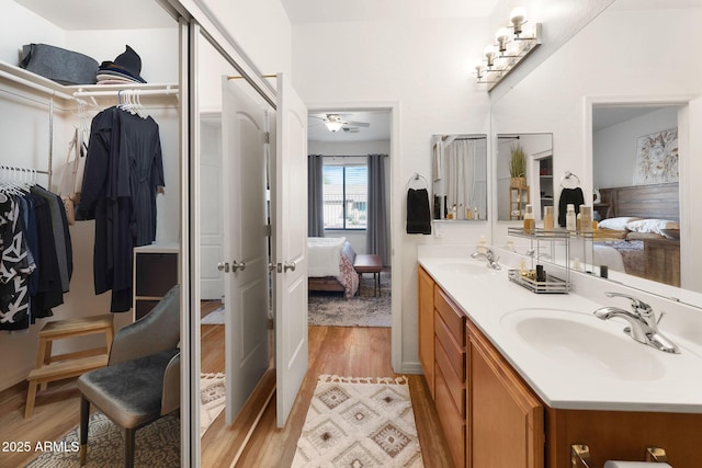 bathroom with double vanity, a spacious closet, a sink, and ensuite bathroom