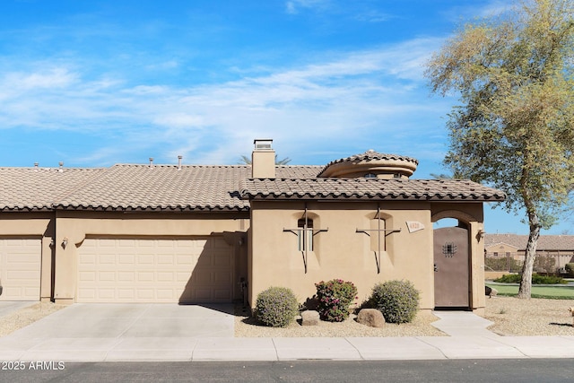 mediterranean / spanish home with a tiled roof, a chimney, driveway, and stucco siding