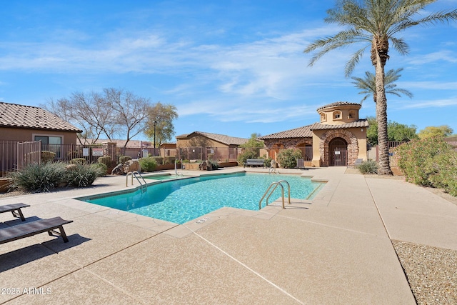 community pool with a patio and fence