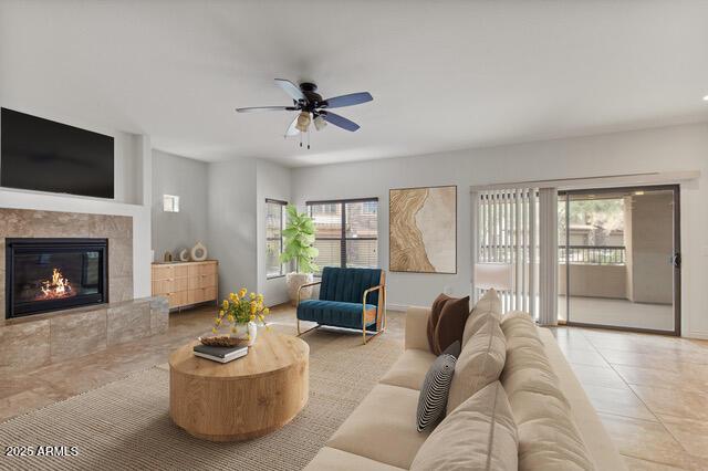 tiled living area with ceiling fan, a fireplace, and a wealth of natural light