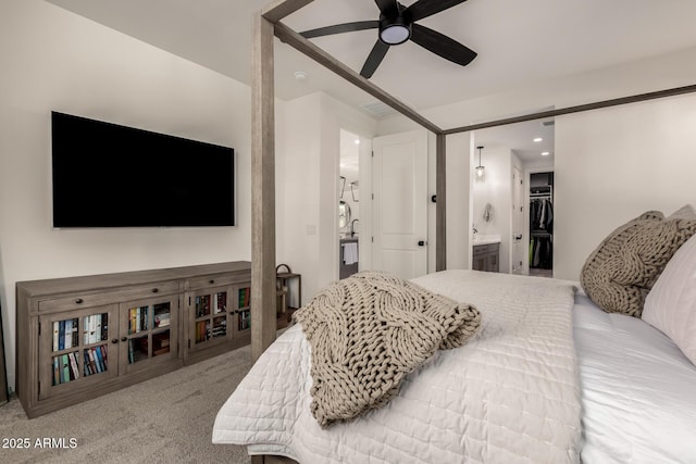 carpeted bedroom with ceiling fan, a walk in closet, ensuite bath, and a closet