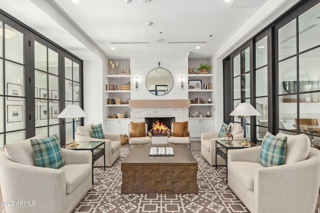 living area with built in shelves and a large fireplace