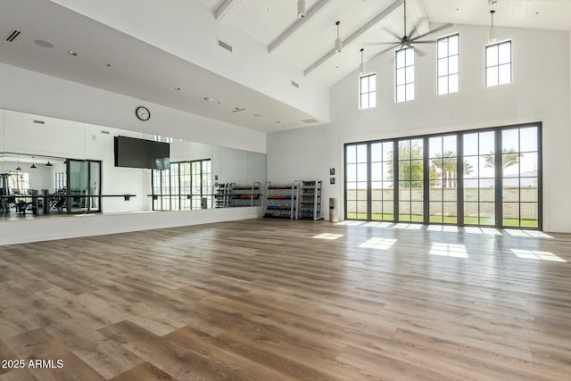 exercise area with ceiling fan, high vaulted ceiling, and hardwood / wood-style floors