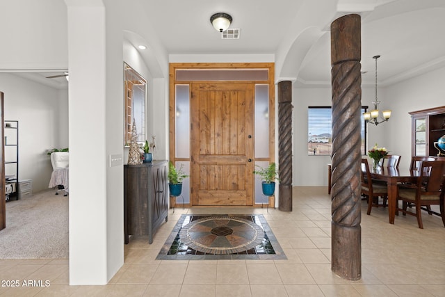 entryway featuring light carpet and ceiling fan with notable chandelier