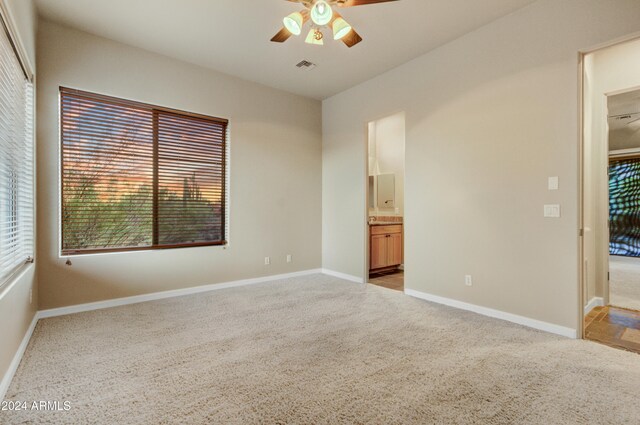 35824 N Tom Darlington Dr, Carefree, AZ 85377 - unfurnished bedroom with light colored carpet, baseboards, ensuite bathroom, and a ceiling fan