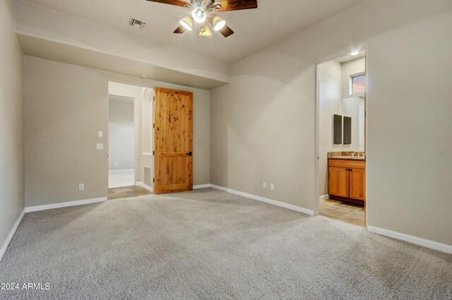 35824 N Tom Darlington Dr, Carefree, AZ 85377 - unfurnished bedroom featuring light colored carpet, baseboards, ensuite bath, and a sink