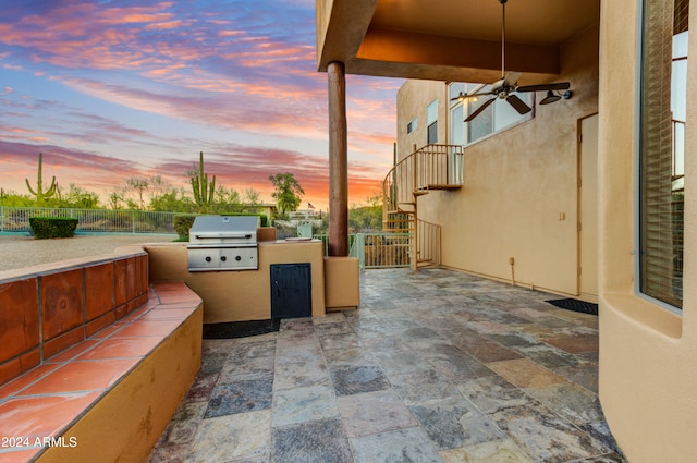 35824 N Tom Darlington Dr, Carefree, AZ 85377 - patio terrace at dusk with a grill, exterior kitchen, and fence