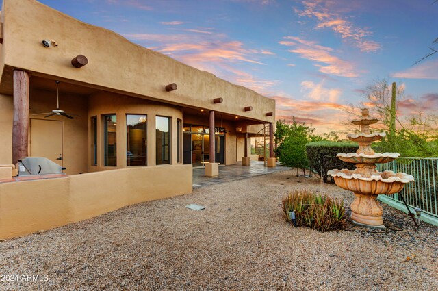 35824 N Tom Darlington Dr, Carefree, AZ 85377 - yard at dusk with a ceiling fan, a patio area, and fence