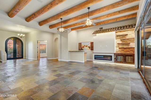 35824 N Tom Darlington Dr, Carefree, AZ 85377 - unfurnished living room with stone tile flooring, arched walkways, a glass covered fireplace, ceiling fan, and beam ceiling