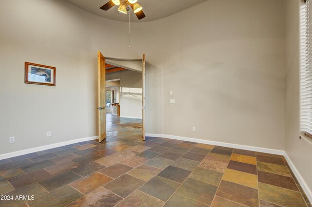 35824 N Tom Darlington Dr, Carefree, AZ 85377 - spare room with stone tile flooring, ceiling fan, baseboards, and a high ceiling