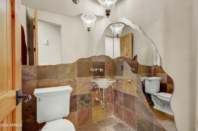 35824 N Tom Darlington Dr, Carefree, AZ 85377 - bathroom featuring tile walls, toilet, stone finish floors, and a sink