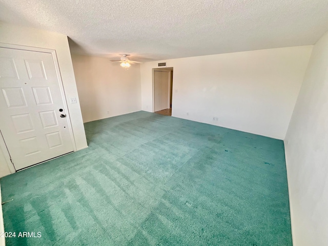 carpeted spare room with a textured ceiling and ceiling fan