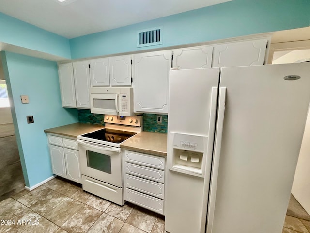 kitchen featuring white appliances, tasteful backsplash, and white cabinets