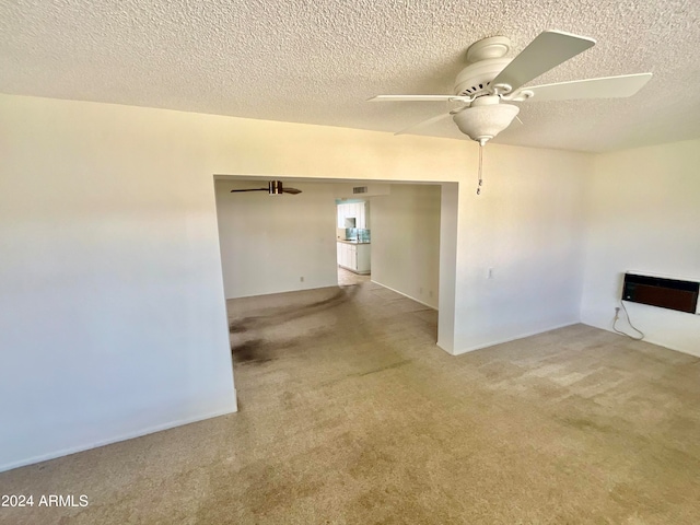 unfurnished room featuring a textured ceiling, ceiling fan, and light colored carpet