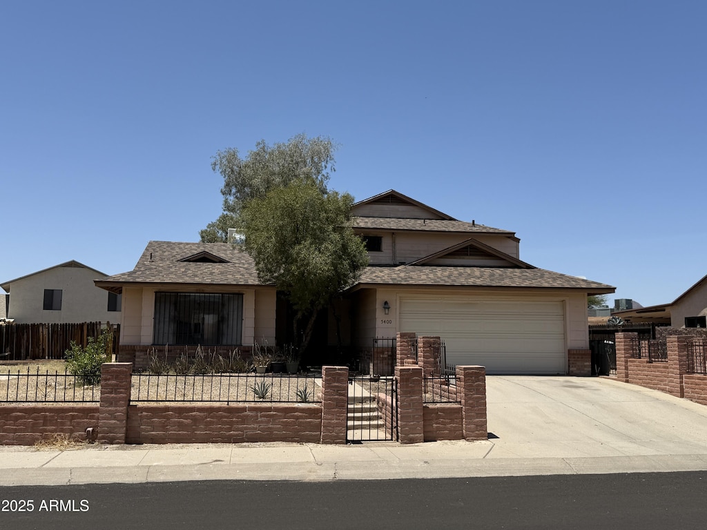 5400 S Southern Oak Dr, Tucson, AZ 85746 - view of front of home with a fenced front yard, concrete driveway, an attached garage, and roof with shingles