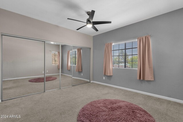 unfurnished bedroom with carpet floors, ceiling fan, and a closet