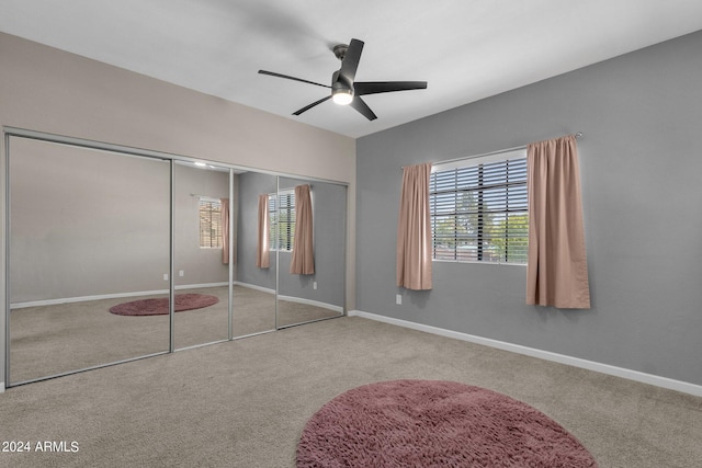 unfurnished bedroom featuring carpet, baseboards, ceiling fan, and a closet