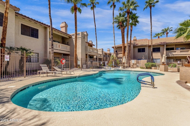 pool featuring fence and a patio